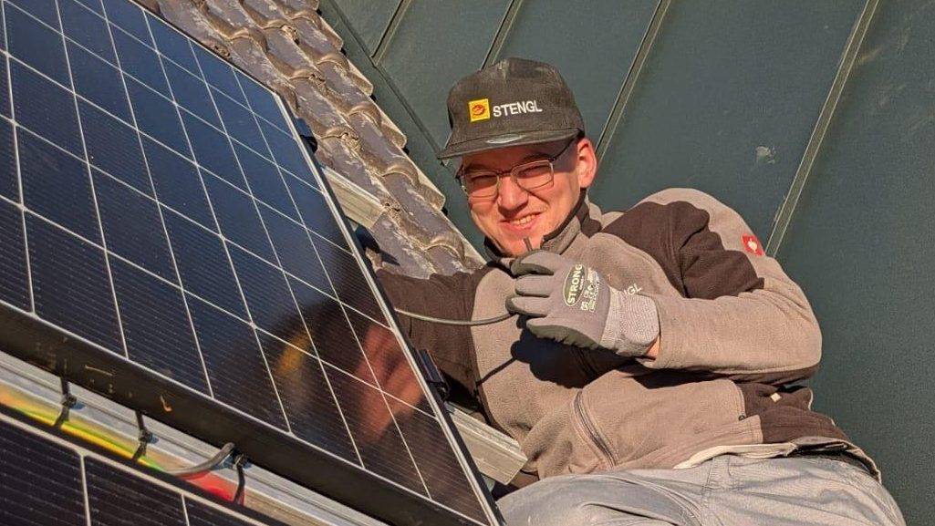 Mitarbeiter Andreas beim Montieren einer PV-Anlage